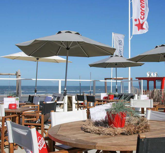 Het terras met parasols en uitzicht op zee